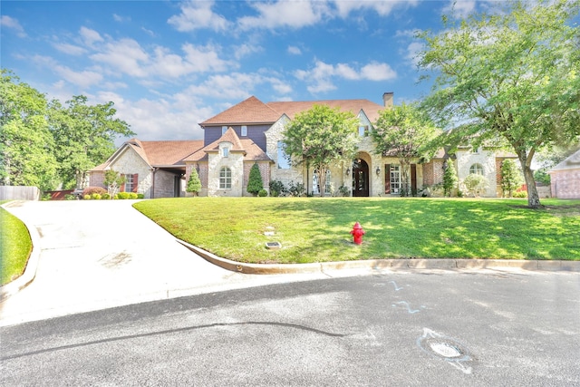 6805 Castle Pines Ct, Tyler, TX 75703 - view of front facade with a front yard, a chimney, stone siding, and brick siding