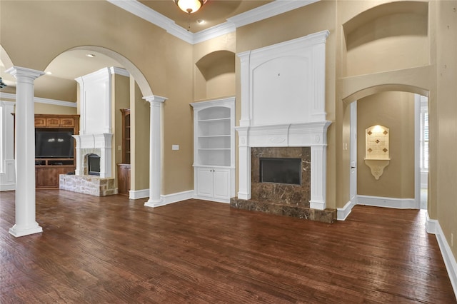 6805 Castle Pines Ct, Tyler, TX 75703 - unfurnished living room with a tile fireplace, dark wood-style floors, crown molding, baseboards, and a towering ceiling
