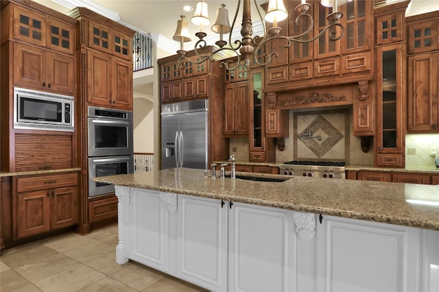 6805 Castle Pines Ct, Tyler, TX 75703 - kitchen featuring built in appliances, a sink, a chandelier, light tile patterned flooring, and tasteful backsplash