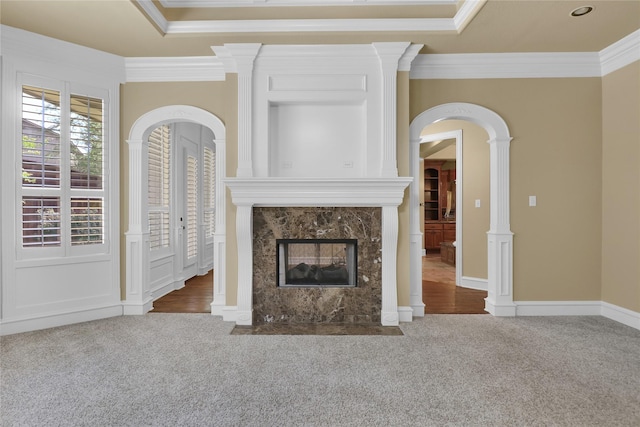 6805 Castle Pines Ct, Tyler, TX 75703 - unfurnished living room featuring carpet flooring, crown molding, a fireplace, and arched walkways