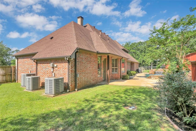 6805 Castle Pines Ct, Tyler, TX 75703 - rear view of house with central AC unit, brick siding, a patio, a chimney, and a shingled roof