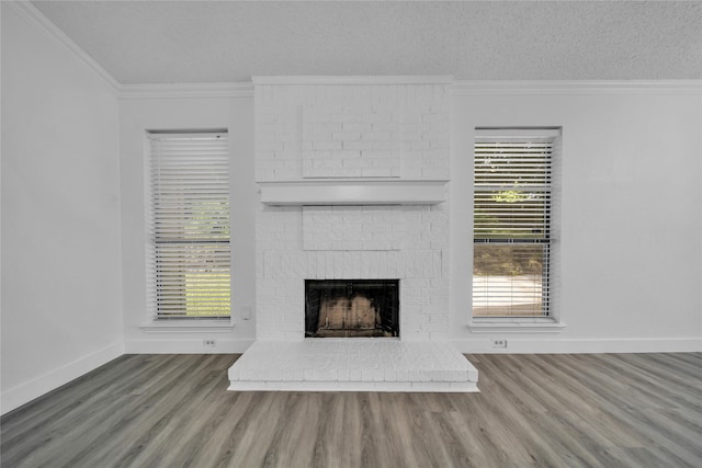 1204 Oak Park Dr, Dallas, TX 75232 - unfurnished living room with crown molding, wood finished floors, a brick fireplace, baseboards, and a textured ceiling