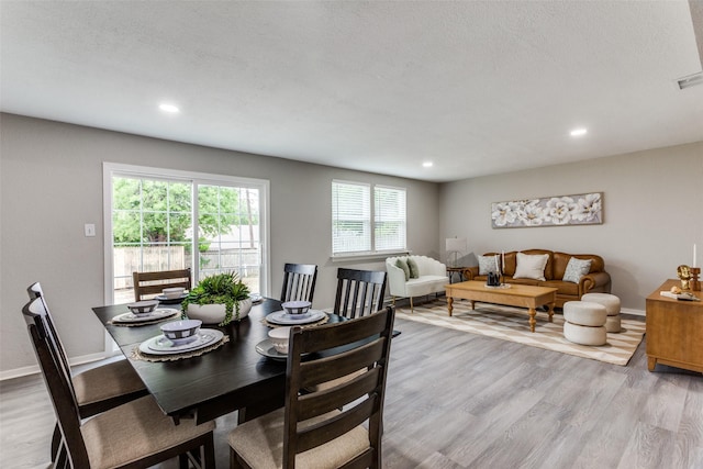 dining space with light wood-style floors, baseboards, recessed lighting, and a textured ceiling