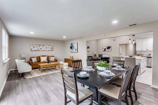 dining space with light wood-type flooring, recessed lighting, and baseboards