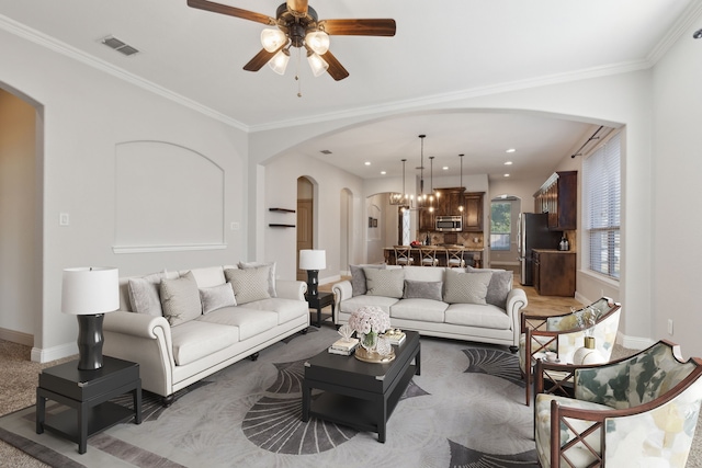 689 Barringer Ct, Fate, TX 75087 - carpeted living room featuring arched walkways, baseboards, ceiling fan, and crown molding