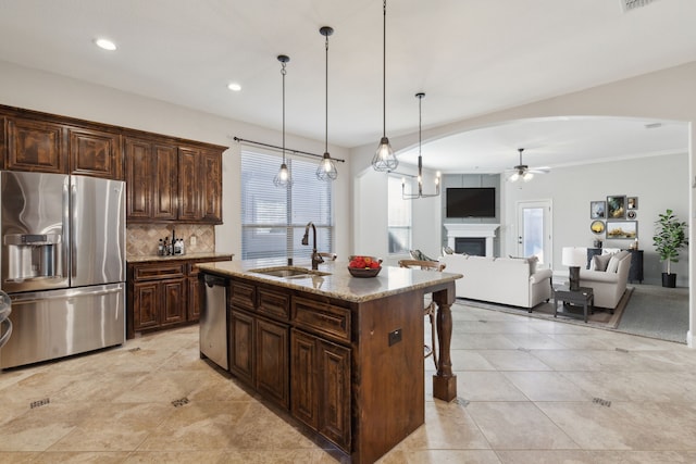 689 Barringer Ct, Fate, TX 75087 - kitchen with appliances with stainless steel finishes, a sink, ceiling fan, decorative backsplash, and plenty of natural light