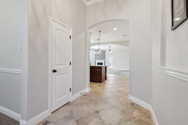 689 Barringer Ct, Fate, TX 75087 - corridor featuring arched walkways, baseboards, crown molding, and light tile patterned floors