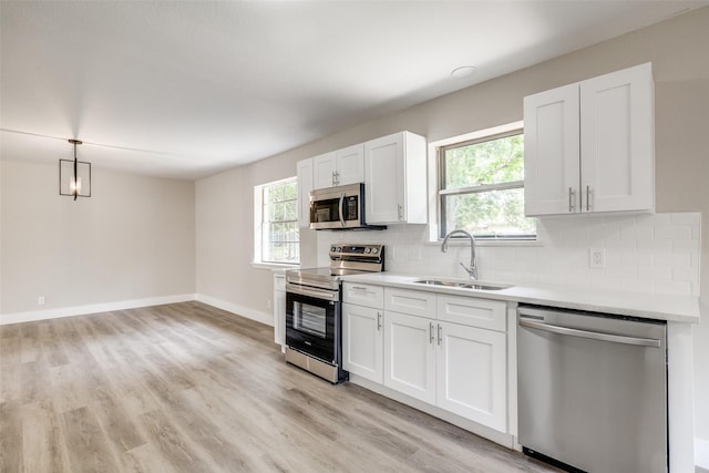 324 Deer Creek Rd, Everman, TX 76140 - kitchen with appliances with stainless steel finishes, a sink, tasteful backsplash, and white cabinets