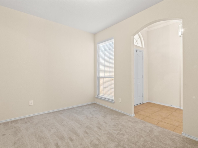 7404 Sunray Dr, Fort Worth, TX 76120 - tiled spare room with arched walkways, carpet flooring, and baseboards