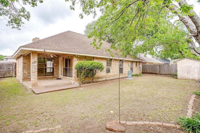 3941 Devonaire Dr, Fort Worth, TX 76008 - back of house with roof with shingles, a fenced backyard, brick siding, and a shed