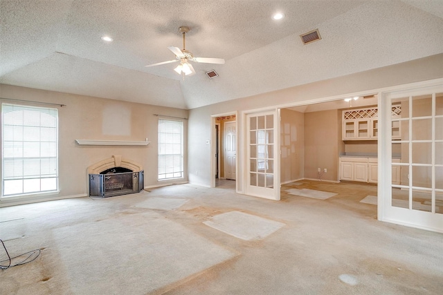 3941 Devonaire Dr, Fort Worth, TX 76008 - unfurnished living room featuring carpet flooring, a textured ceiling, a fireplace with flush hearth, a ceiling fan, and french doors
