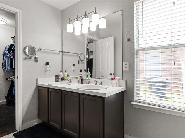 1429 Trading Post Dr, Fort Worth, TX 76131 - full bath featuring double vanity, a textured wall, wood finished floors, baseboards, and a spacious closet