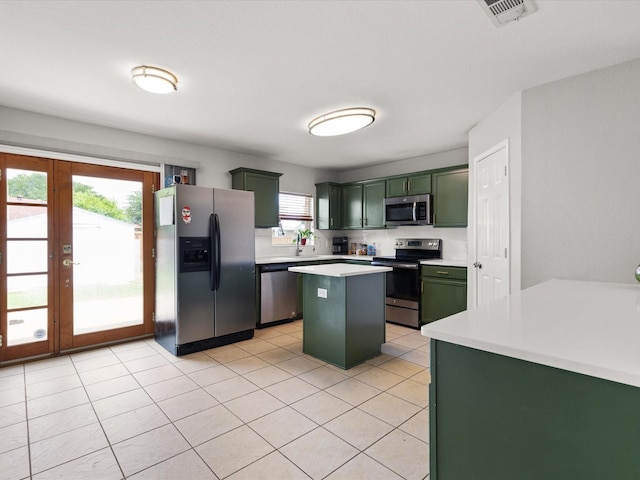 1429 Trading Post Dr, Fort Worth, TX 76131 - kitchen featuring stainless steel appliances, green cabinets, light countertops, a center island, and light tile patterned flooring