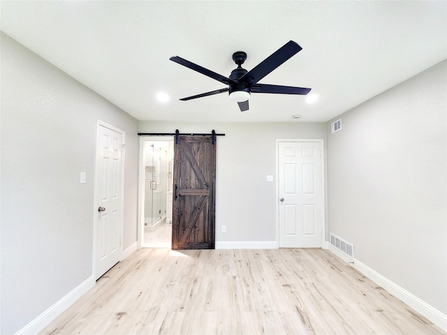 227 Rodeo Dr, Keller, TX 76248 - unfurnished bedroom with light wood finished floors, a barn door, baseboards, ensuite bathroom, and ceiling fan