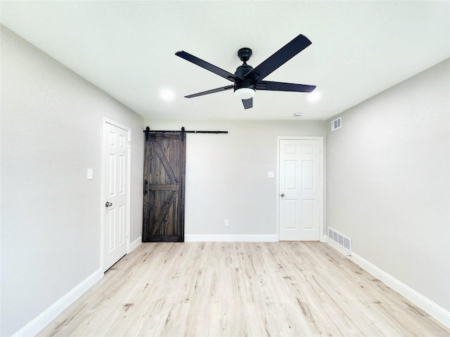 227 Rodeo Dr, Keller, TX 76248 - unfurnished bedroom with a barn door, wood finished floors, and baseboards