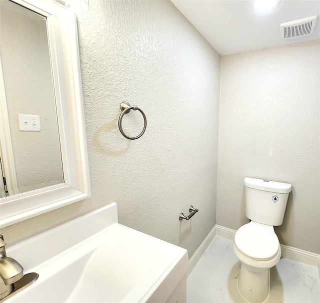 227 Rodeo Dr, Keller, TX 76248 - bathroom featuring marble look tile flooring, toilet, and baseboards