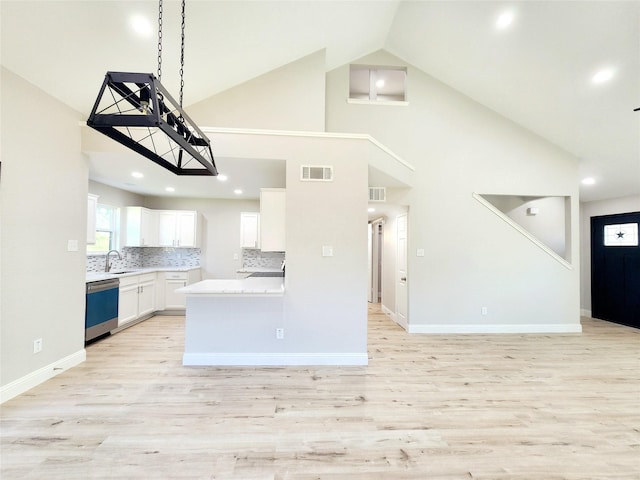 227 Rodeo Dr, Keller, TX 76248 - kitchen with dishwashing machine, white cabinetry, light wood-style floors, light countertops, and high vaulted ceiling