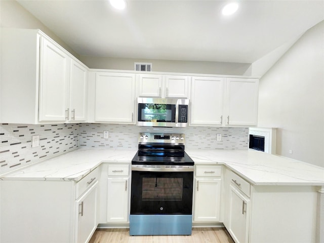 227 Rodeo Dr, Keller, TX 76248 - kitchen featuring stainless steel appliances, a peninsula, white cabinetry, light stone counters, and recessed lighting