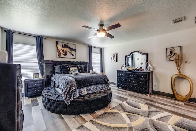 703 Moss Glen Trl, Arlington, TX 76002 - bedroom featuring wood finished floors, a textured ceiling, ceiling fan, and baseboards