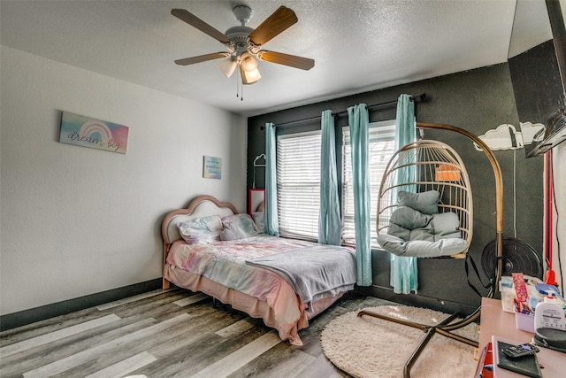 703 Moss Glen Trl, Arlington, TX 76002 - bedroom with wood finished floors, ceiling fan, baseboards, and a textured ceiling