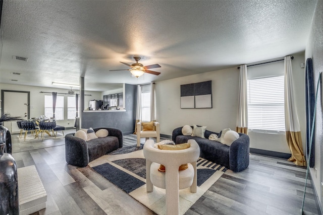 703 Moss Glen Trl, Arlington, TX 76002 - living room featuring a textured ceiling, wood finished floors, a ceiling fan, and baseboards