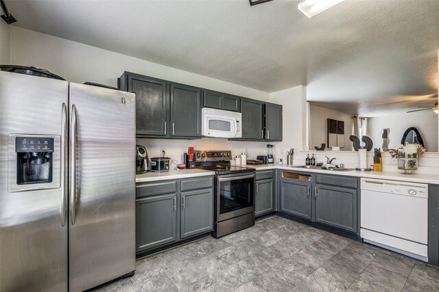 703 Moss Glen Trl, Arlington, TX 76002 - kitchen with stainless steel appliances, light countertops, a sink, gray cabinetry, and a textured ceiling