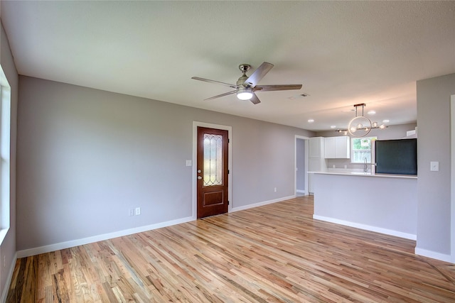 2189 Rs County Road 3150, Emory, TX 75440 - unfurnished living room featuring a chandelier, light wood finished floors, a ceiling fan, and baseboards