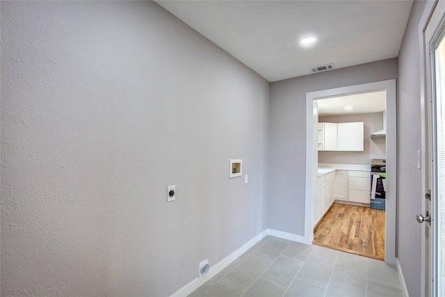 2189 Rs County Road 3150, Emory, TX 75440 - laundry area featuring electric dryer hookup, washer hookup, baseboards, light tile patterned floors, and cabinet space