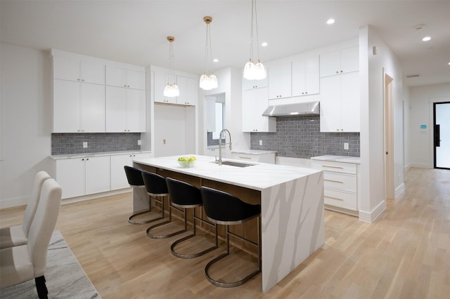 2935 Lovers Ln, University Park, TX 75225 - kitchen with a sink, under cabinet range hood, backsplash, a kitchen island with sink, and recessed lighting