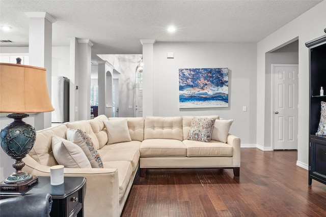 living area featuring a textured ceiling, dark wood-type flooring, recessed lighting, arched walkways, and baseboards
