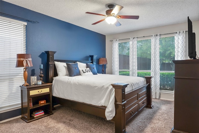 bedroom featuring a textured ceiling, carpet, and ceiling fan