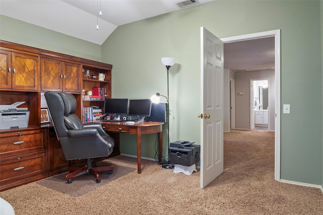 carpeted home office featuring vaulted ceiling and baseboards