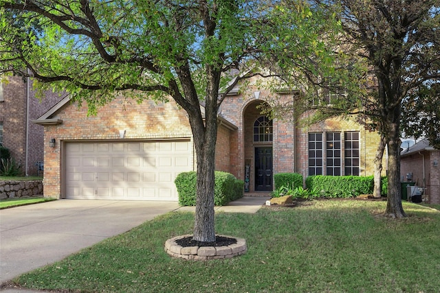 traditional-style home with brick siding, driveway, an attached garage, and a front lawn