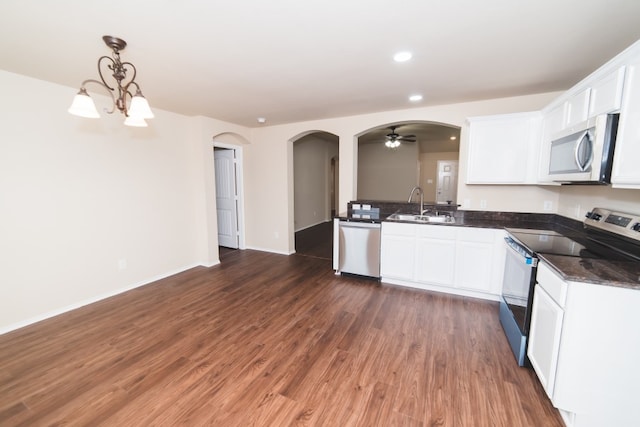 2105 Meadow View Dr, Princeton, TX 75407 - kitchen with stainless steel appliances, a sink, arched walkways, wood finished floors, and white cabinets