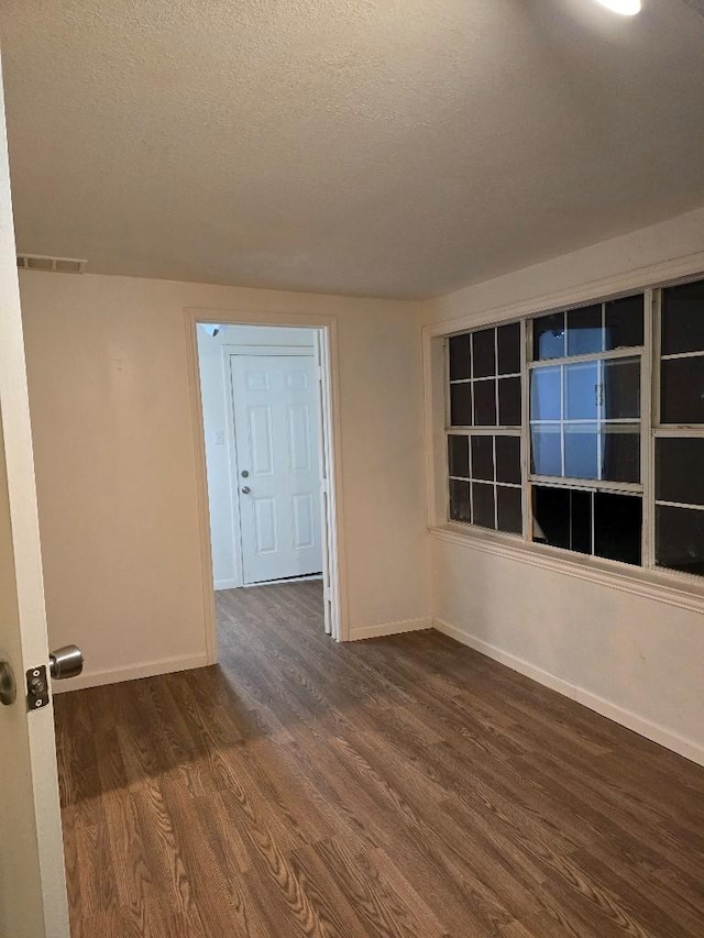 3915 Flory St, North Richland Hills, TX 76180 - unfurnished room with dark wood-style flooring, a textured ceiling, and baseboards