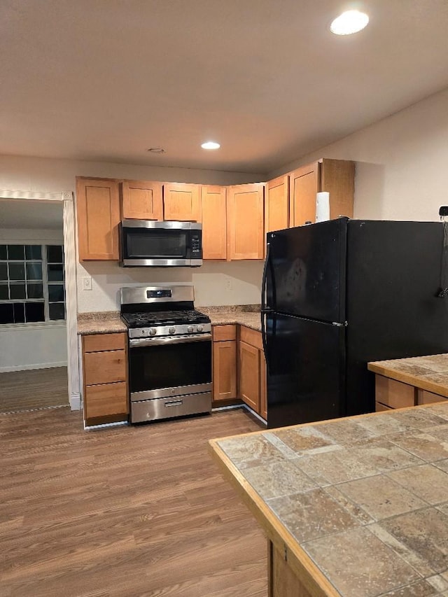 3915 Flory St, North Richland Hills, TX 76180 - kitchen with stainless steel appliances, wood finished floors, recessed lighting, light countertops, and light brown cabinets