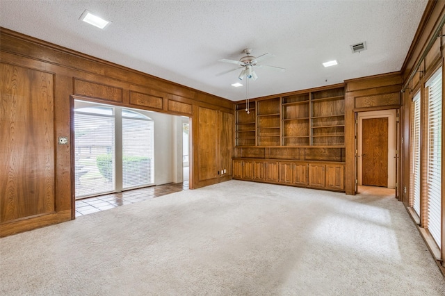 4312 High Spgs, Arlington, TX 76016 - unfurnished living room featuring wooden walls, ceiling fan, light colored carpet, and a textured ceiling