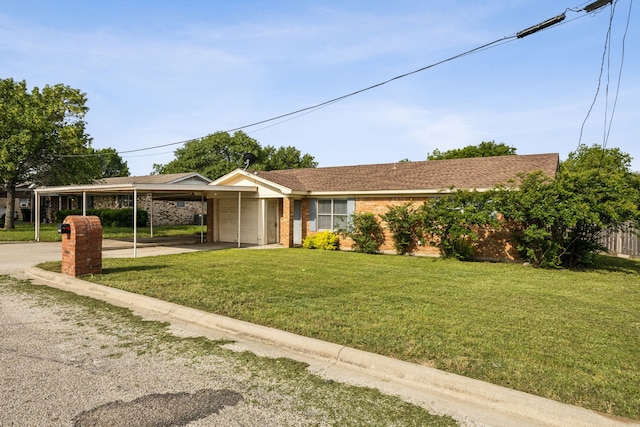 1003 N Washburn St, Decatur, TX 76234 - view of front facade featuring a carport, a garage, a front yard, concrete driveway, and brick siding