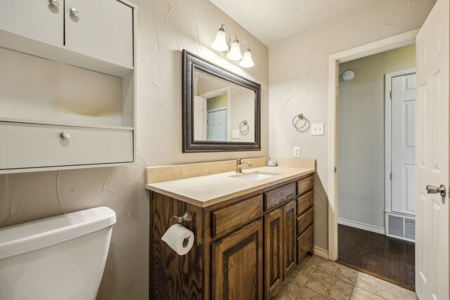 1003 N Washburn St, Decatur, TX 76234 - half bathroom with toilet, vanity, tile patterned floors, and baseboards