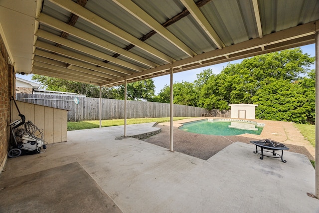 1003 N Washburn St, Decatur, TX 76234 - view of swimming pool with a patio area, a fire pit, a fenced backyard, and a storage unit