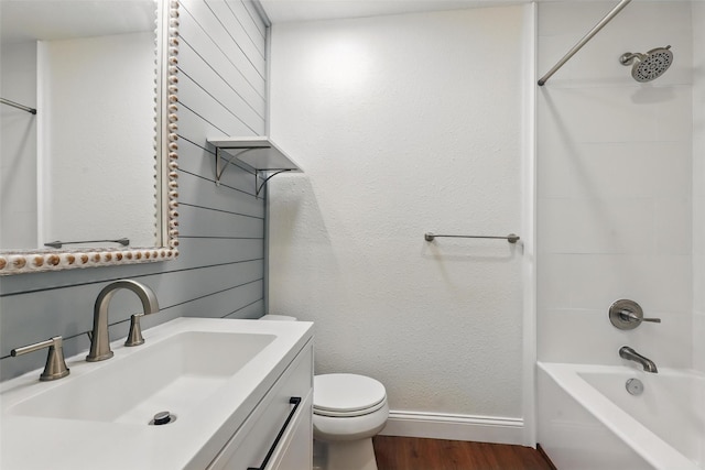 513 Edna Ct, Everman, TX 76140 - bathroom featuring wood finished floors, toilet, baseboards, vanity, and bathing tub / shower combination