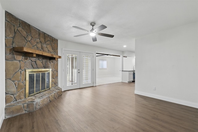 513 Edna Ct, Everman, TX 76140 - unfurnished living room featuring ceiling fan, baseboards, wood finished floors, a stone fireplace, and french doors