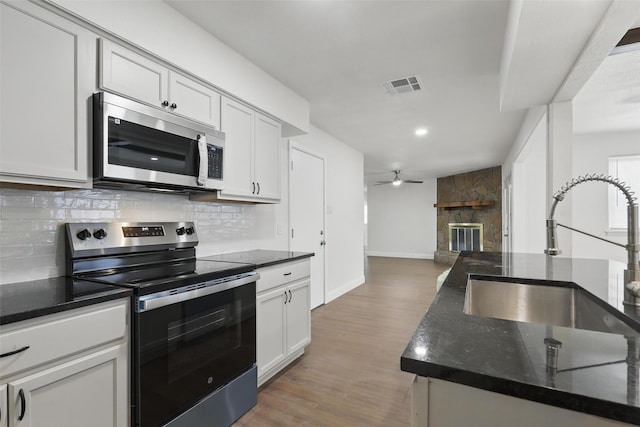 513 Edna Ct, Everman, TX 76140 - kitchen featuring stainless steel appliances, a sink, decorative backsplash, baseboards, and ceiling fan