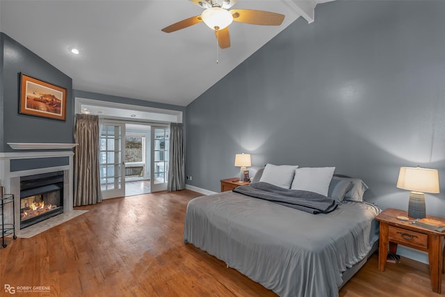bedroom with wood finished floors, access to outside, baseboards, a fireplace with flush hearth, and ceiling fan