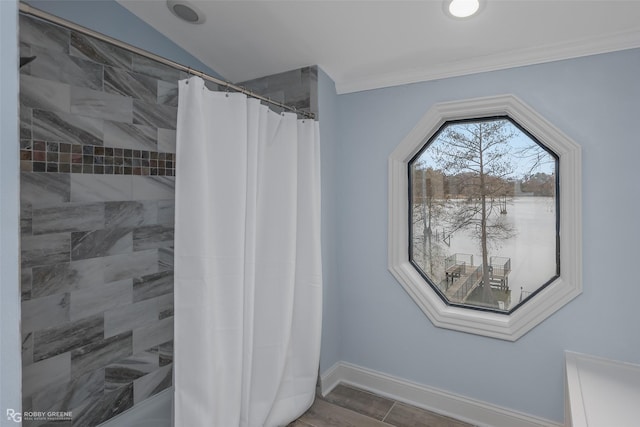 bathroom with baseboards, a shower with shower curtain, and crown molding