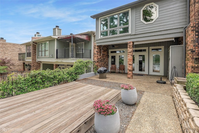back of house featuring french doors, brick siding, and fence