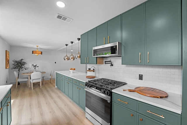 8338 Bocowood Dr, Dallas, TX 75228 - kitchen with appliances with stainless steel finishes, decorative backsplash, light wood-type flooring, green cabinets, and decorative light fixtures