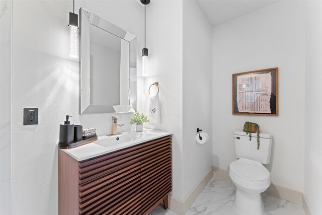 8338 Bocowood Dr, Dallas, TX 75228 - bathroom with baseboards, marble look tiles, toilet, and vanity