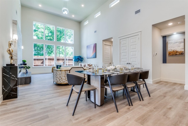 13554 Pyramid Dr, Farmers Branch, TX 75234 - dining space featuring a towering ceiling, light wood finished floors, baseboards, plenty of natural light, and recessed lighting