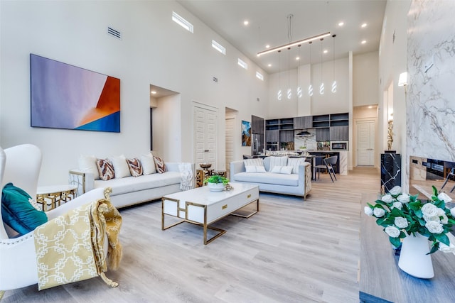 13554 Pyramid Dr, Farmers Branch, TX 75234 - living area featuring a towering ceiling, light wood-style floors, and recessed lighting